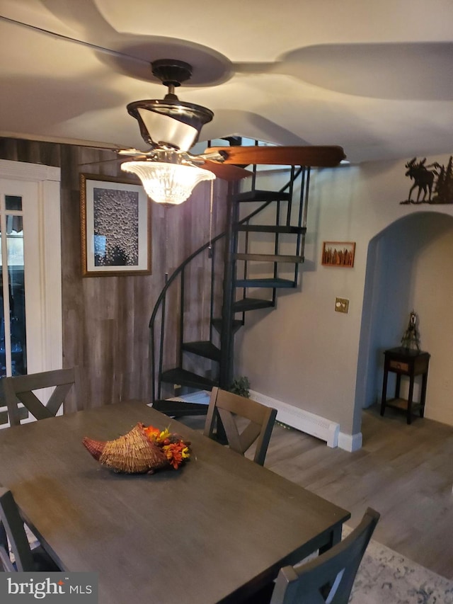 dining space with hardwood / wood-style floors, an inviting chandelier, and a baseboard radiator