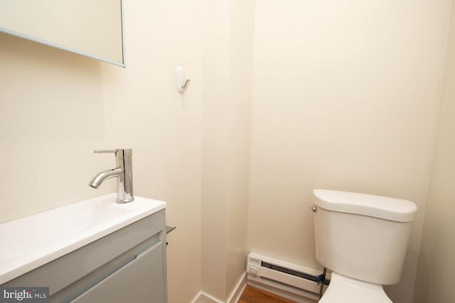 bathroom with hardwood / wood-style floors, vanity, toilet, and a baseboard radiator