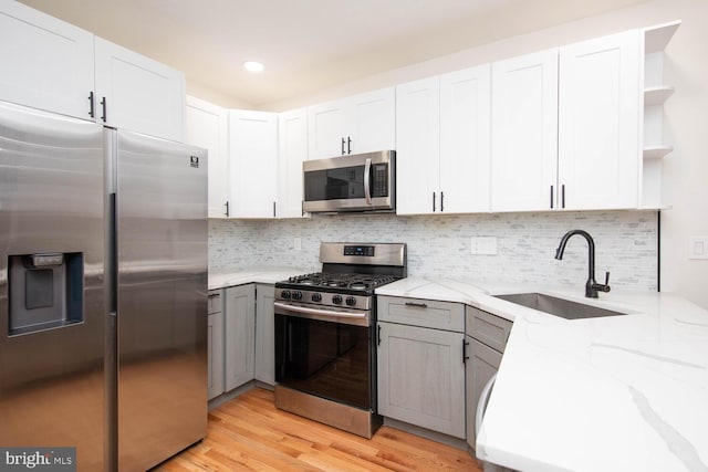 kitchen featuring light stone countertops, appliances with stainless steel finishes, and white cabinetry