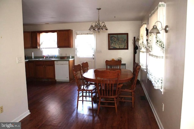 dining area with dark hardwood / wood-style floors, sink, and a chandelier