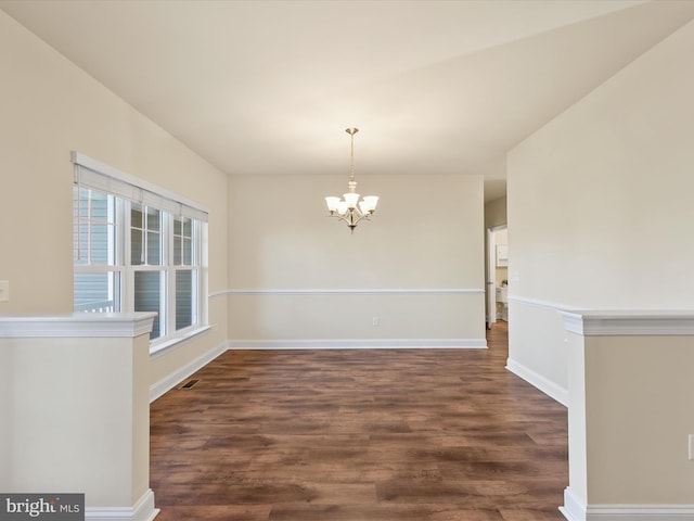 unfurnished dining area featuring a notable chandelier and dark hardwood / wood-style flooring