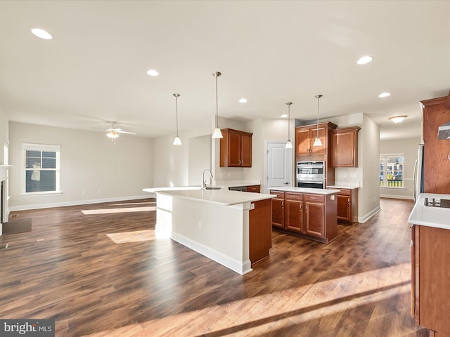 kitchen with appliances with stainless steel finishes, hanging light fixtures, and dark wood-type flooring