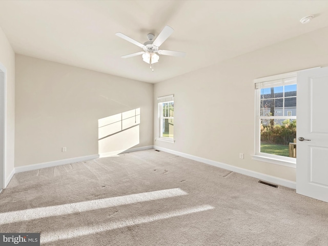 empty room featuring ceiling fan and light carpet