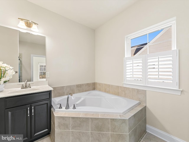 bathroom with tile patterned flooring, vanity, and a relaxing tiled tub