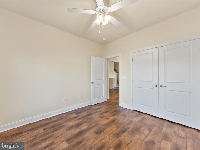 unfurnished bedroom with dark hardwood / wood-style floors, ceiling fan, and a closet