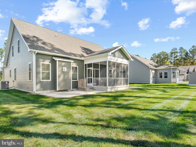 rear view of property with central air condition unit, a patio area, a sunroom, and a yard