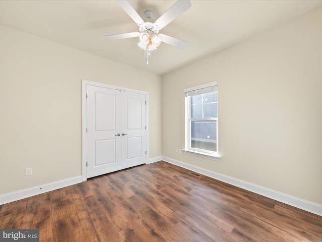 unfurnished bedroom featuring a closet, ceiling fan, and dark hardwood / wood-style flooring