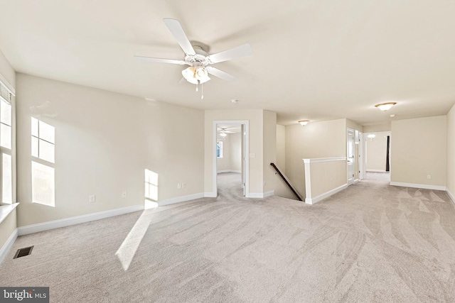 empty room featuring ceiling fan and light colored carpet