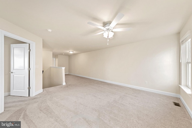 carpeted spare room featuring ceiling fan and a healthy amount of sunlight