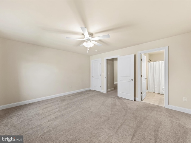 unfurnished bedroom with connected bathroom, light colored carpet, and ceiling fan