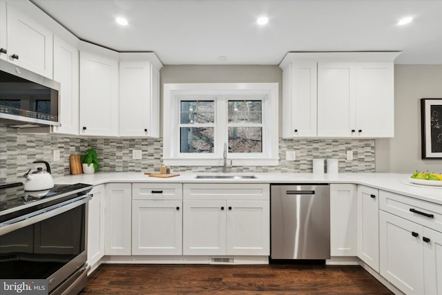 kitchen featuring backsplash, sink, white cabinetry, and stainless steel appliances