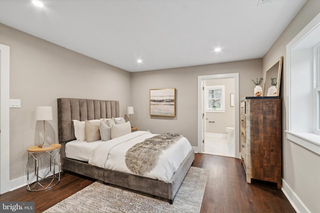 bedroom featuring dark hardwood / wood-style flooring and connected bathroom