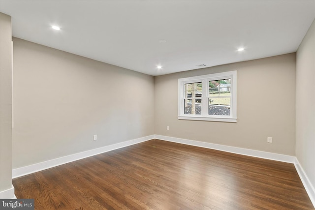 unfurnished room with dark wood-type flooring