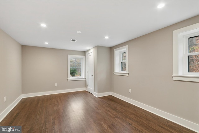 spare room featuring dark wood-type flooring and a wealth of natural light