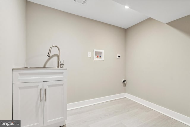 washroom featuring hookup for an electric dryer, hookup for a washing machine, cabinets, sink, and light hardwood / wood-style floors