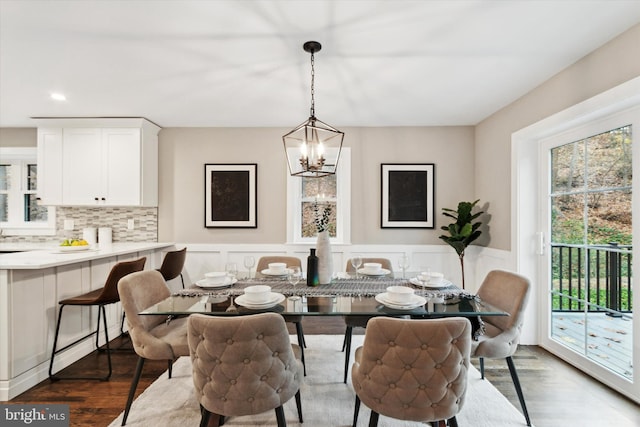 dining space with dark wood-type flooring and a notable chandelier