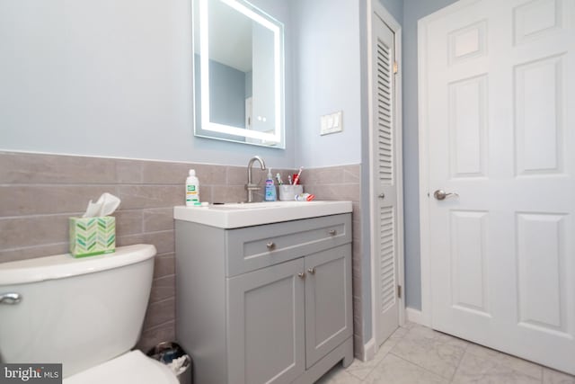 4504 Harbor Beach Blvd, Brigantine, NJ 08203 - bathroom with tile walls, toilet, vanity, marble finish flooring, and wainscoting