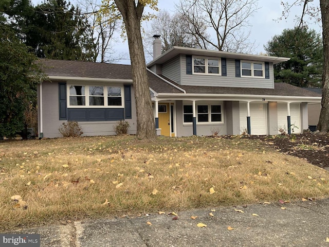 view of front of property with a front yard and a garage