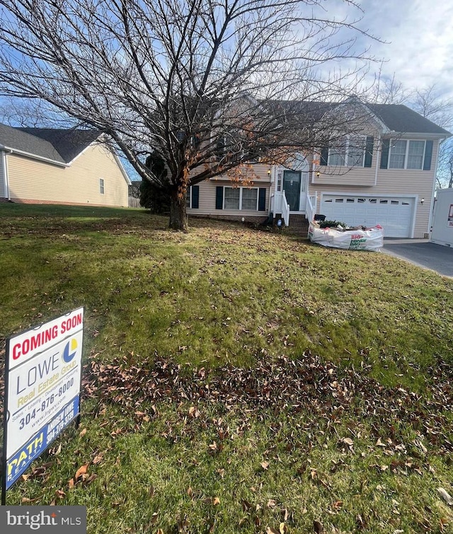 raised ranch featuring a front lawn and a garage