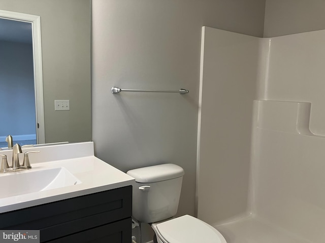 bathroom featuring walk in shower, vanity, and toilet