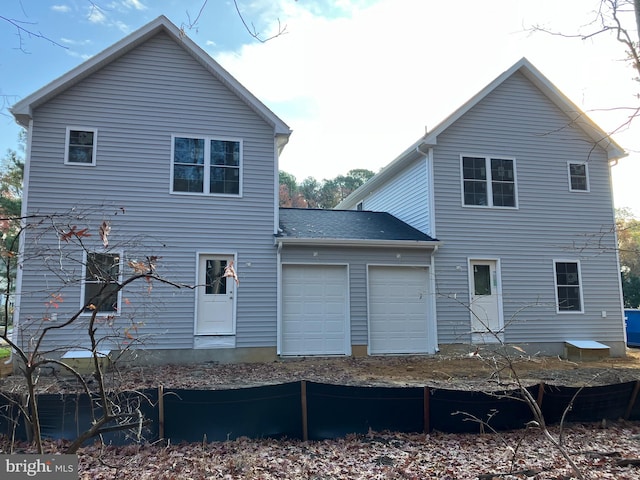 rear view of property with a garage