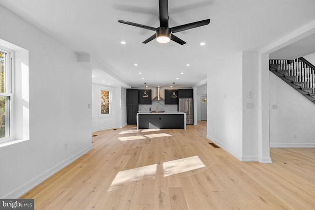 unfurnished living room featuring light hardwood / wood-style flooring, plenty of natural light, and ceiling fan