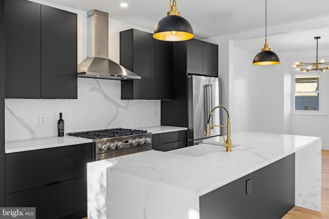 kitchen featuring high end appliances, light hardwood / wood-style flooring, hanging light fixtures, and wall chimney range hood