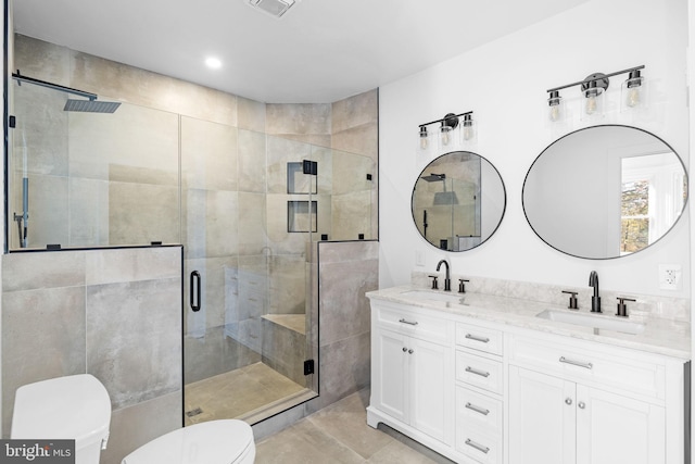 bathroom featuring tile patterned flooring, a shower with door, vanity, and toilet