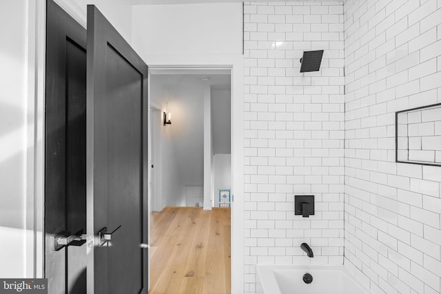 bathroom featuring wood-type flooring and tiled shower / bath combo