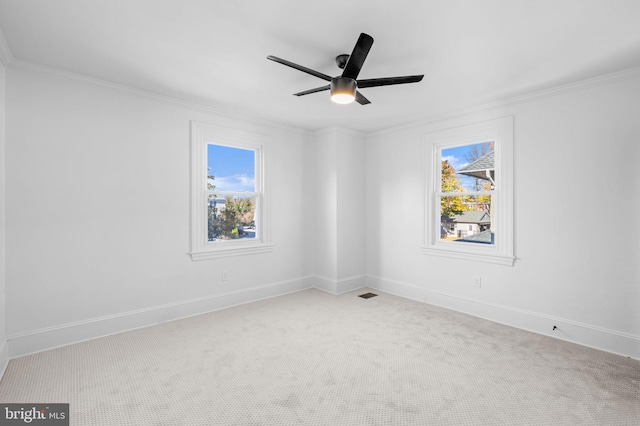 carpeted empty room with ceiling fan and crown molding