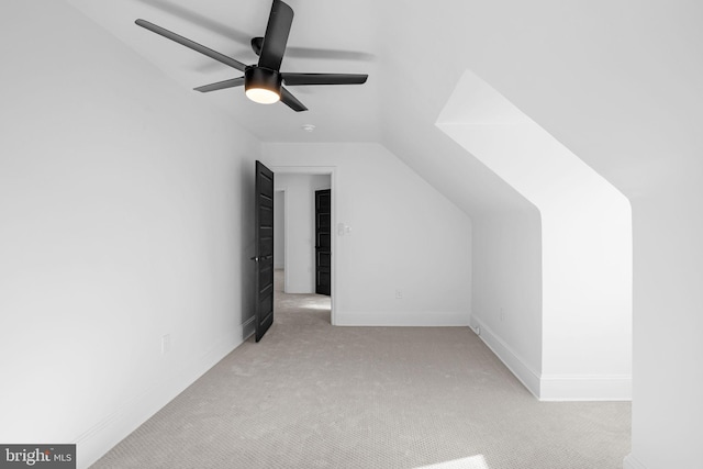 additional living space with light colored carpet, ceiling fan, and lofted ceiling