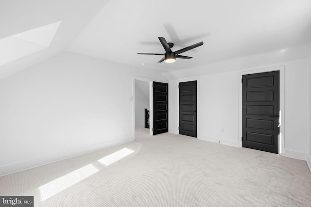 unfurnished bedroom with ceiling fan, light colored carpet, and lofted ceiling