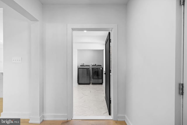 corridor with hardwood / wood-style floors and washer and clothes dryer