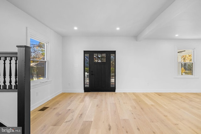 foyer with beamed ceiling and light hardwood / wood-style floors