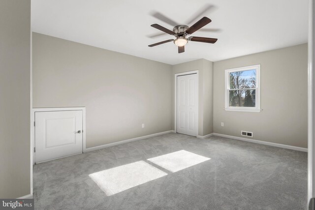 interior space with light carpet and ceiling fan