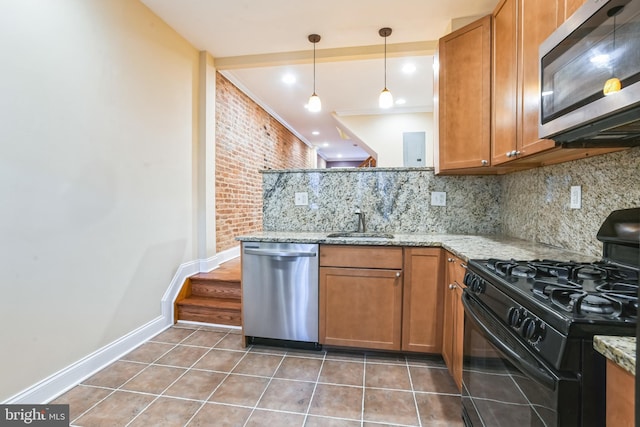 kitchen with sink, decorative backsplash, light stone countertops, ornamental molding, and appliances with stainless steel finishes