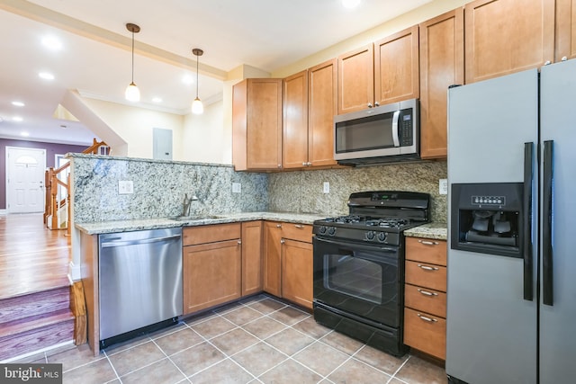 kitchen with sink, hanging light fixtures, stainless steel appliances, tasteful backsplash, and light stone counters