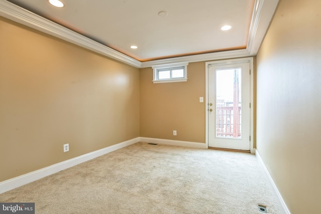 spare room featuring ornamental molding, light carpet, and a tray ceiling