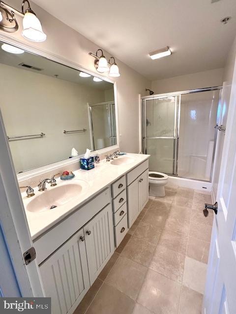 bathroom featuring vanity, toilet, and a shower with shower door