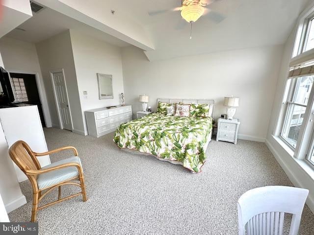 bedroom with light carpet, multiple windows, and ceiling fan