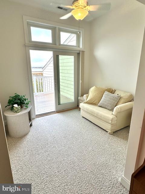 carpeted living room featuring ceiling fan