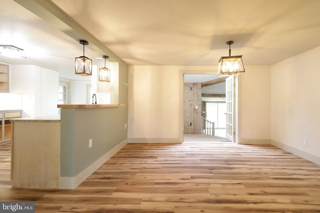 unfurnished dining area with a chandelier, light hardwood / wood-style floors, and sink