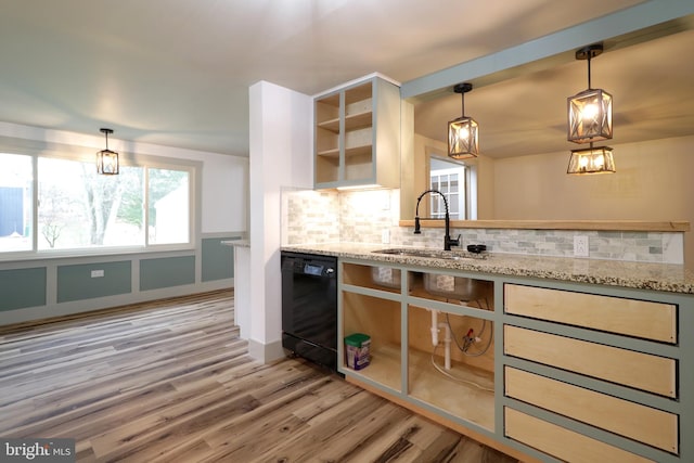 kitchen with backsplash, light stone counters, sink, light hardwood / wood-style flooring, and black dishwasher