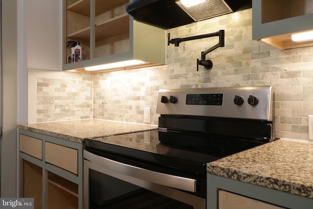 kitchen featuring stainless steel range with electric stovetop, light stone countertops, backsplash, and range hood