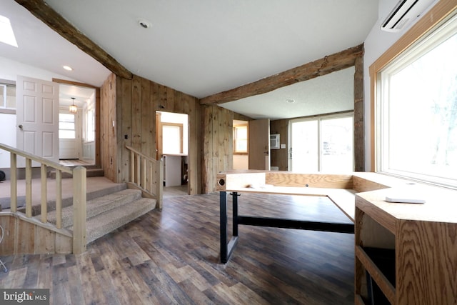 recreation room with a wealth of natural light, dark hardwood / wood-style flooring, lofted ceiling with beams, and a wall mounted air conditioner