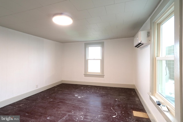 empty room with dark hardwood / wood-style floors and an AC wall unit