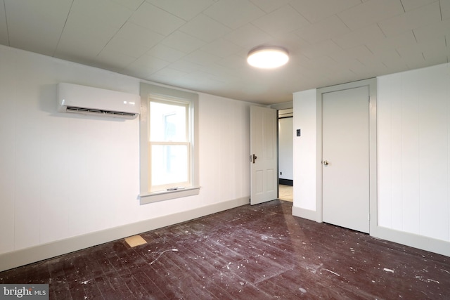 unfurnished bedroom with dark hardwood / wood-style flooring and a wall mounted AC