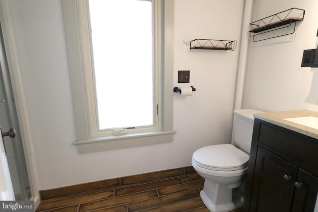 bathroom with hardwood / wood-style floors, vanity, and toilet