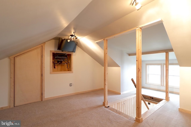 additional living space with light carpet and vaulted ceiling