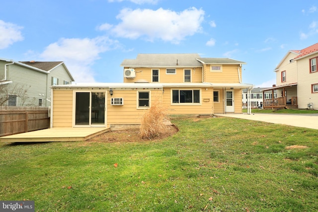 rear view of property featuring a deck and a yard